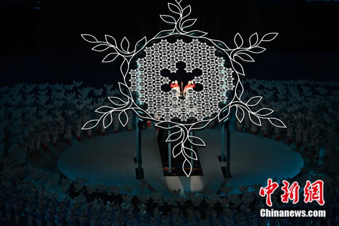2022年2月4日晚，第二十四届冬季奥林匹克运动会开幕式在北京国家体育场举行。图为迪妮格尔-依拉木江和赵嘉文将最后一棒火炬留在“大雪花”中心。<a target='_blank' href='http://www.chinanews.com/'>中新社</a>记者 毛建军 摄