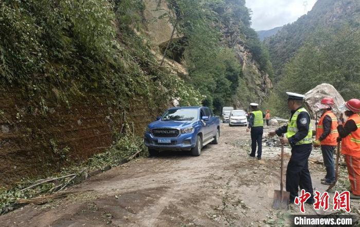 甘孜州公安交警等救援力量正在抢通地震中受损的道路，疏散车辆。　甘孜州公安局供图