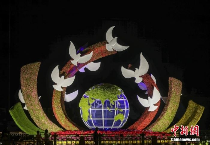 9月26日晚，北京长安街沿线国庆主题花坛亮灯，市民在参观军事博物馆前广场布置的“命运共同体”花坛。 <a target='_blank' href='/'>中新社</a>记者 易海菲 摄